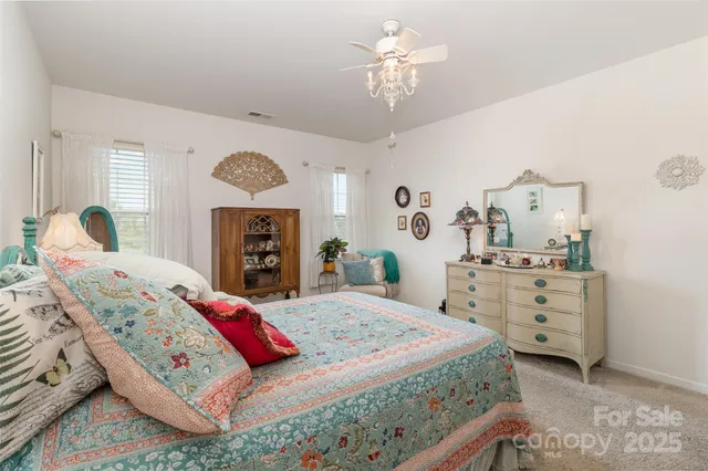 a bedroom with a bed mirror and a chandelier