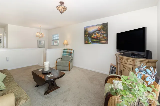 a bedroom with a bed a chair and a large window