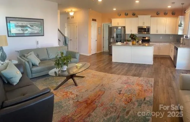 a living room with furniture and kitchen view