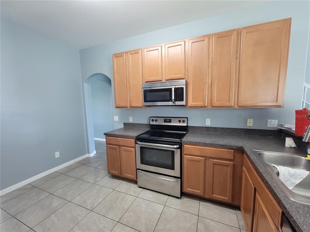 2734 Rochelle Drive Winter Haven, FL 33881 - Photo 6 of 38 a kitchen with granite countertop a stove top oven microwave and cabinets