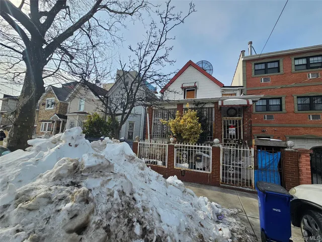 a view of a house with a wooden fence and a pathway
