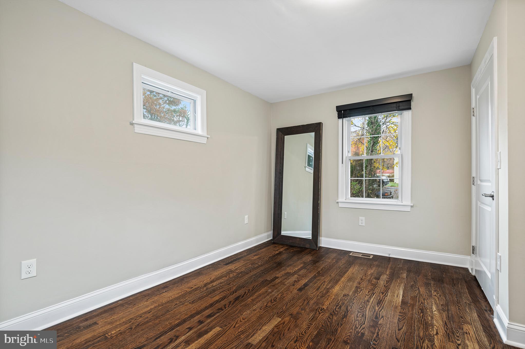 9217 Fowler Lane Lanham, MD 20706 - Photo 37 of 80 a view of an empty room with wooden floor and a window