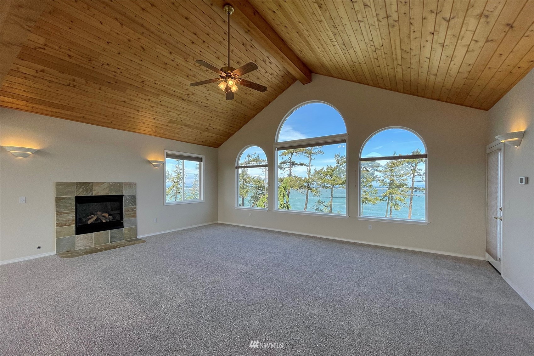 402 Marine Drive Sequim, WA 98382 - Photo 15 of 40 an empty room with windows chandelier and fireplace