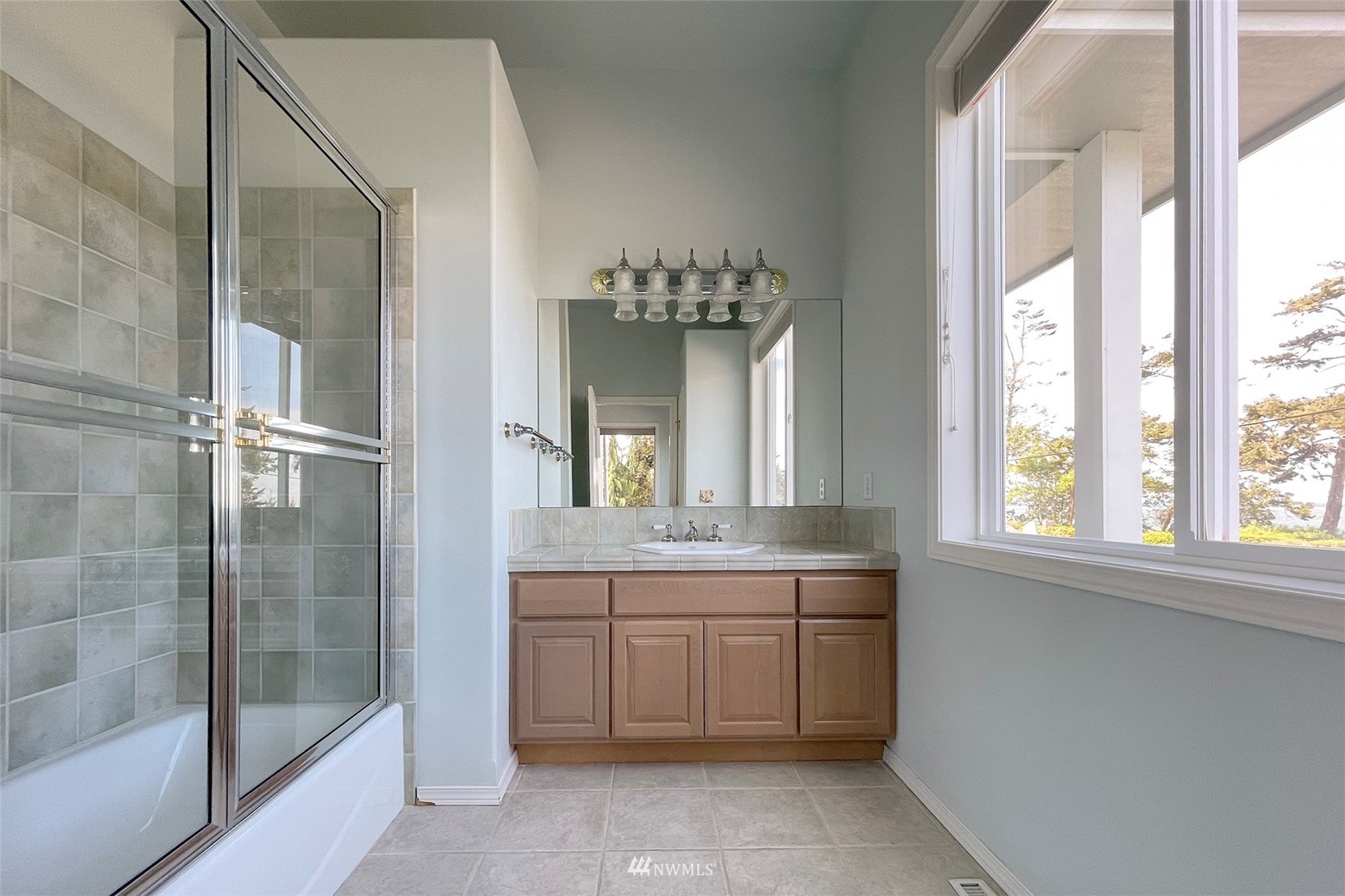402 Marine Drive Sequim, WA 98382 - Photo 34 of 40 a bathroom with a double vanity sink and mirror with bathtub