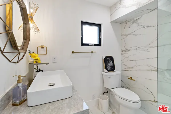 a bathroom with a sink mirror and toilet
