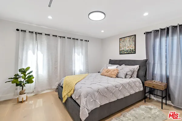 a bedroom with a bed and a potted plant