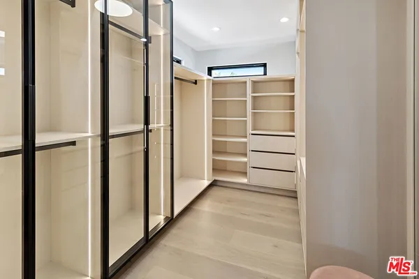 a view of walk in closet with empty racks