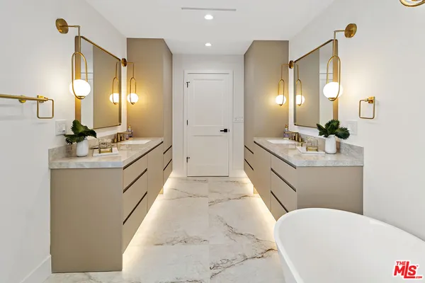 a bathroom with a double vanity sink mirror and bathtub