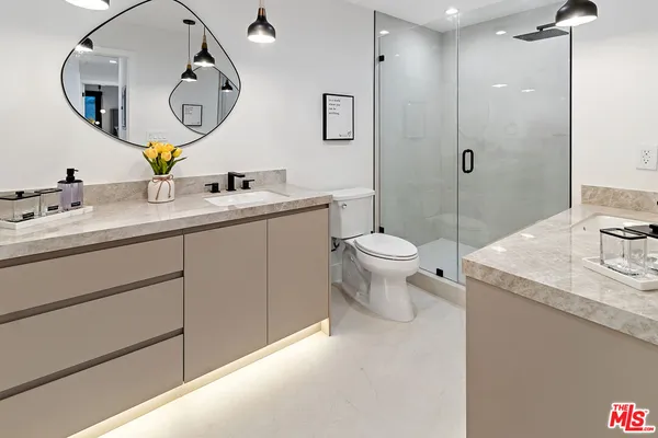 a bathroom with a granite countertop sink mirror a toilet and a mirror