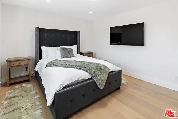 a bedroom with a bed and a flat screen tv