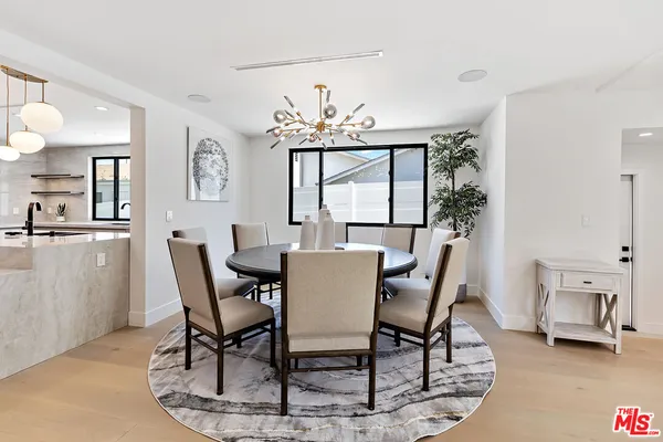 a dining room with furniture a chandelier and window