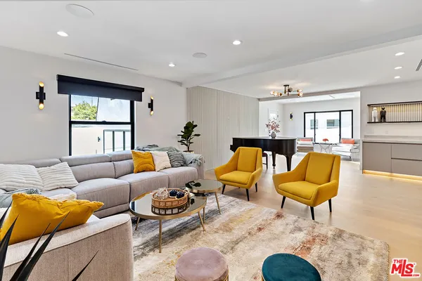 a living room with furniture kitchen view and a window