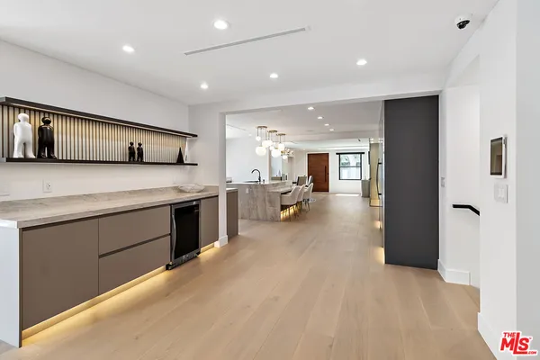 a large white kitchen with a refrigerator and a sink