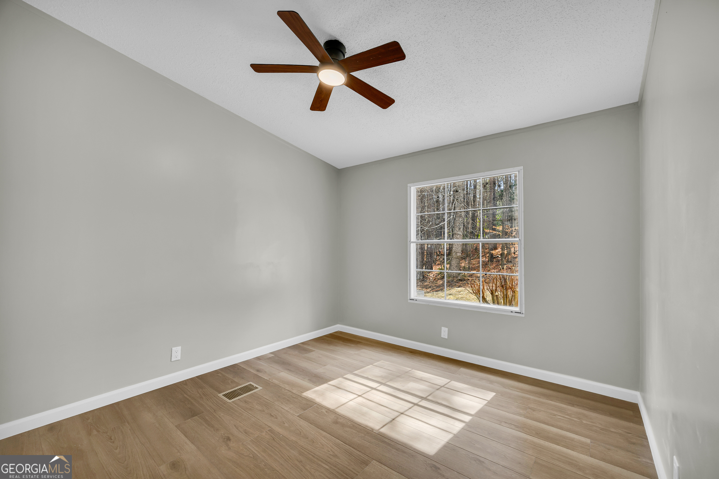 60 Tribble Bottoms Road Arnoldsville, GA 30619 - Photo 22 of 66 an empty room with wooden floor and windows