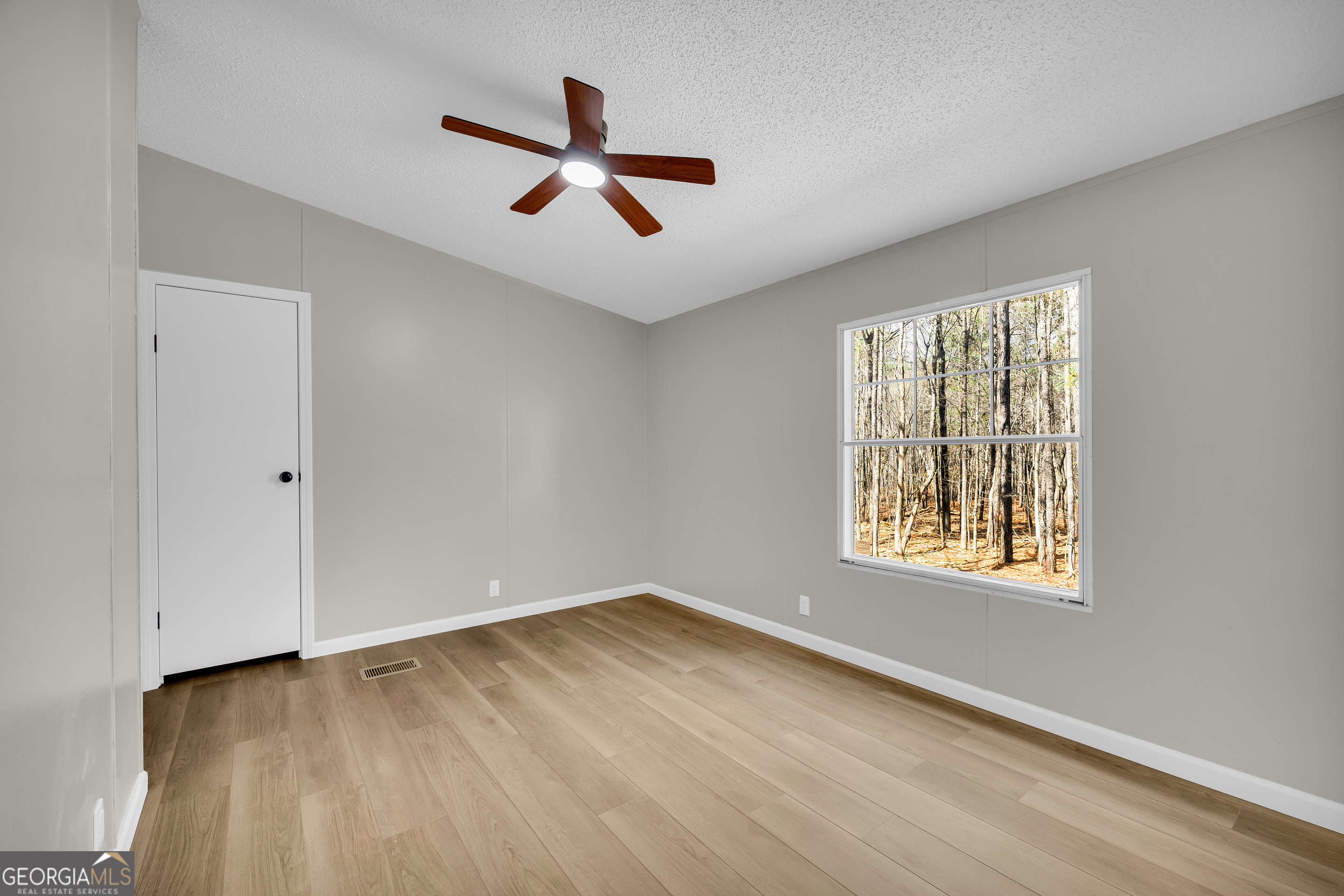 60 Tribble Bottoms Road Arnoldsville, GA 30619 - Photo 26 of 66 a view of an empty room with wooden floor and a window
