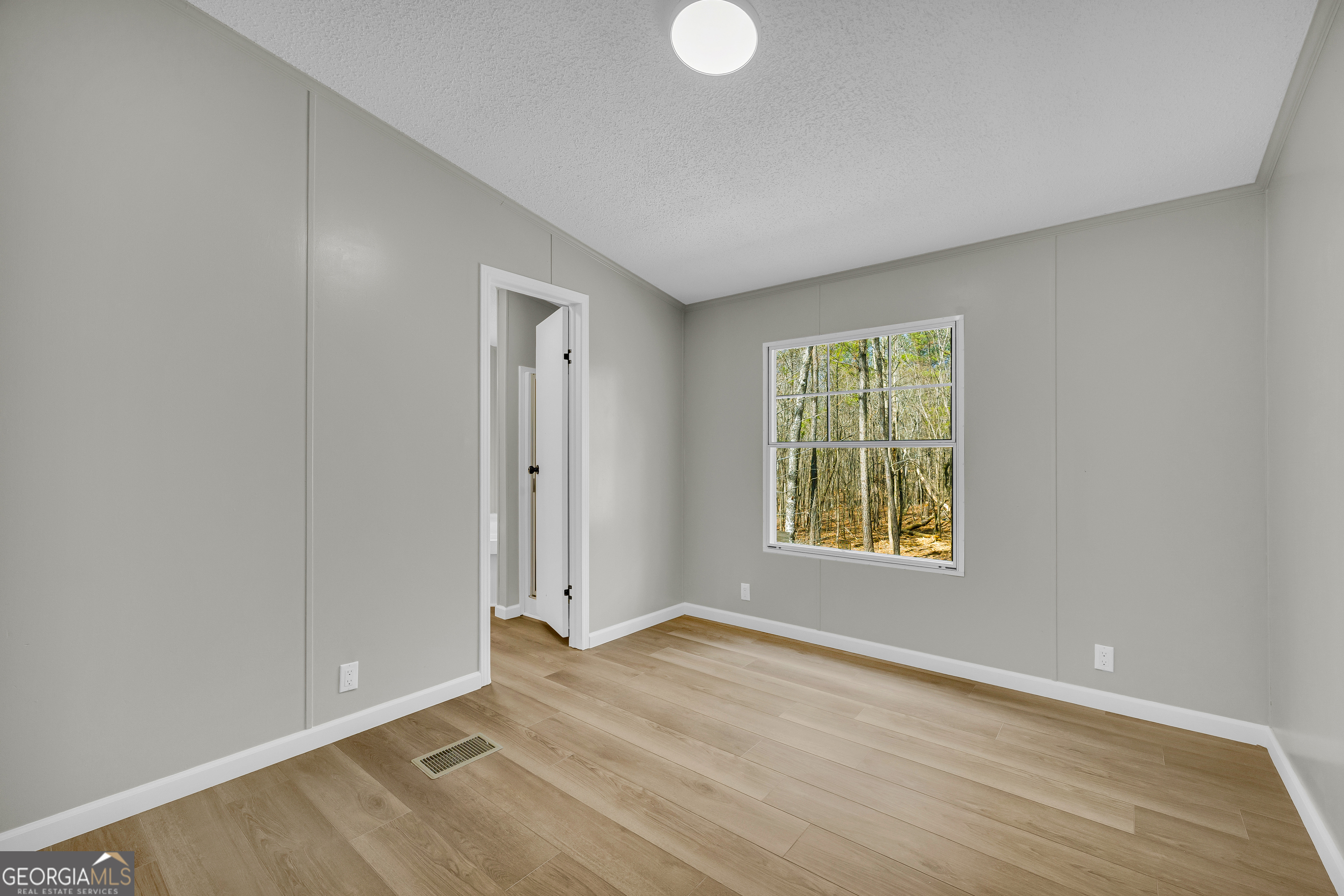 60 Tribble Bottoms Road Arnoldsville, GA 30619 - Photo 35 of 66 a view of an empty room with wooden floor and a window