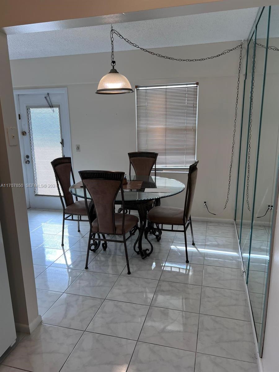 324 Fanshaw H, Unit 324H Boca Raton, FL 33434 - Photo 5 of 13 a view of a dining room with furniture and chandelier