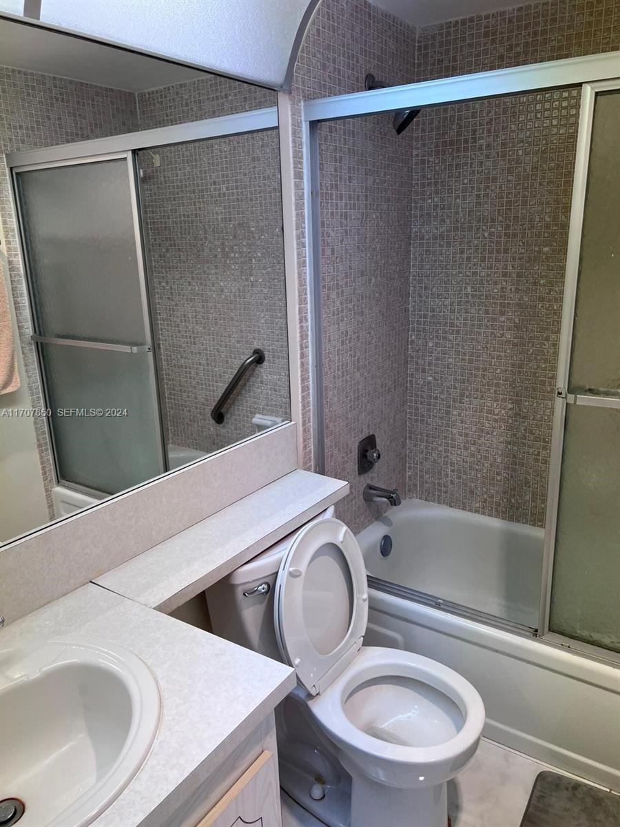 324 Fanshaw H, Unit 324H Boca Raton, FL 33434 - Photo 6 of 13 a bathroom with a sink a toilet and shower