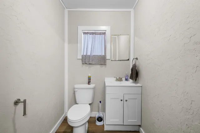 a bathroom with a toilet sink vanity and mirror