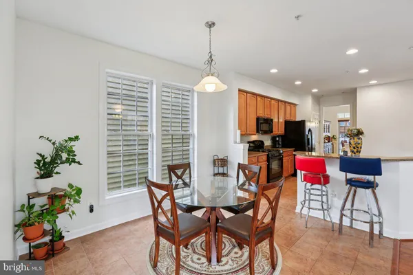 a dining room filled with furniture and a potted plant