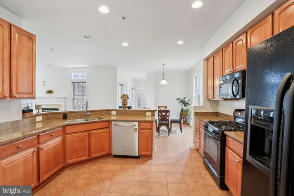 a kitchen with stainless steel appliances granite countertop sink stove top oven and cabinets