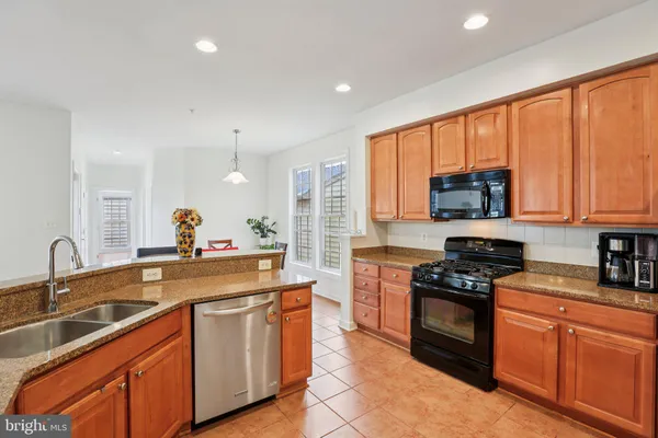 a kitchen with stainless steel appliances granite countertop a stove sink and cabinets