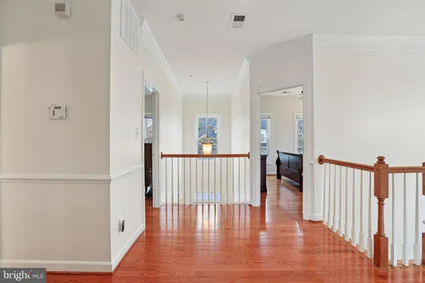 a view of a hallway with wooden floor and windows