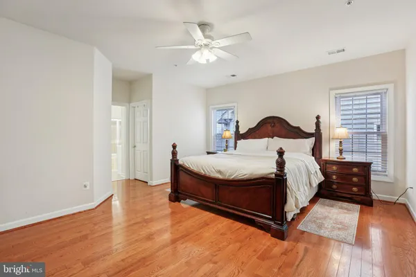 a bed sitting in a spacious bedroom next to a window