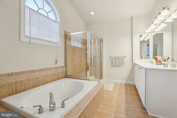 a bathroom with a tub a sink and a shower