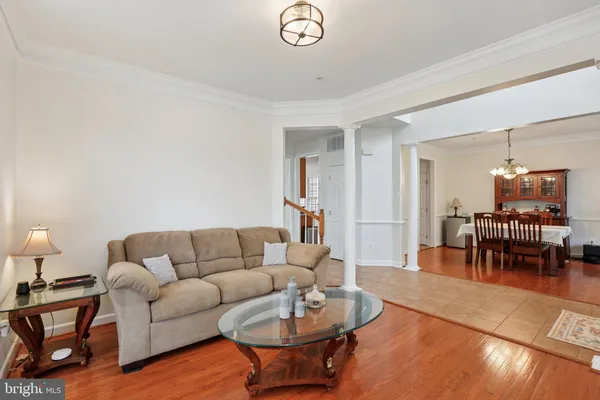 a living room with furniture a dining table and a chandelier