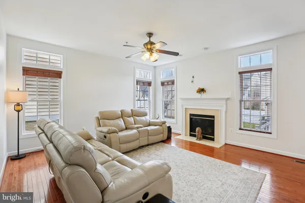 a living room with furniture a fireplace and wooden floor