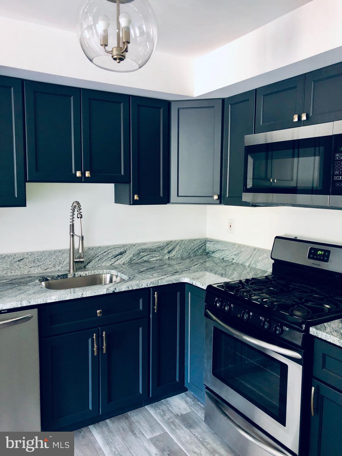 301 Trinity Court, Unit 10 Princeton, NJ 08540 - Photo 3 of 19 a kitchen with granite countertop wooden cabinets and stainless steel appliances