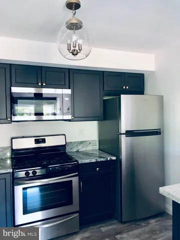 a kitchen with stainless steel appliances granite countertop a refrigerator a stove and a sink