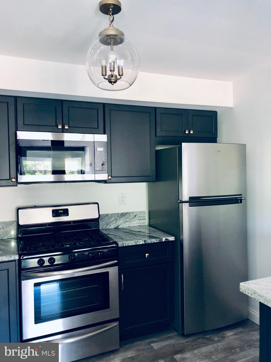 301 Trinity Court, Unit 10 Princeton, NJ 08540 - Photo 5 of 19 a kitchen with stainless steel appliances granite countertop a refrigerator a stove and a sink
