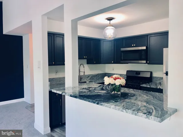 a kitchen with stainless steel appliances granite countertop a refrigerator and a stove top oven