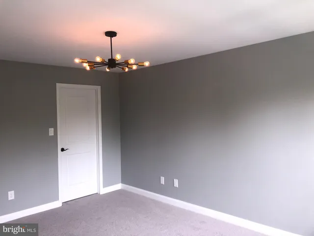 a view of a chandelier fan in big room