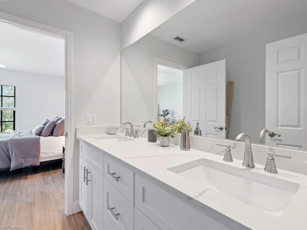 709 Augusta Boulevard, Unit 7095 Naples, FL 34113 - Photo 8 of 16 Bathroom with hardwood / wood-style floors and double vanity