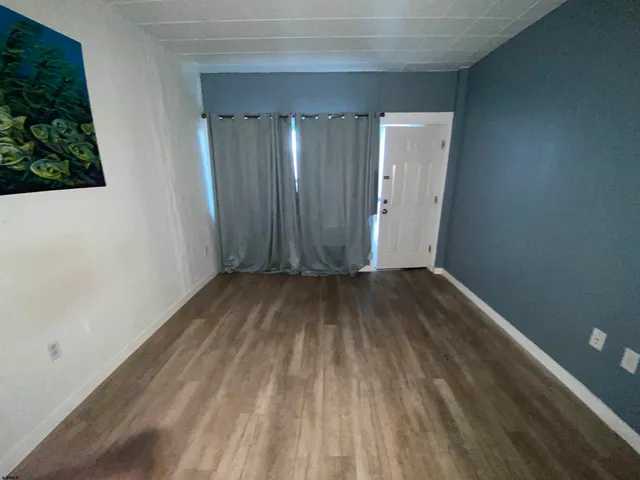 a view of a room with wooden floor and entryway