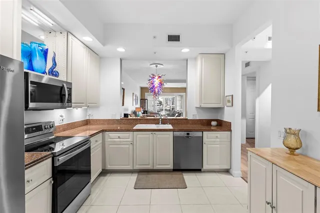 a kitchen with stainless steel appliances granite countertop a sink and dishwasher a refrigerator with wooden floor