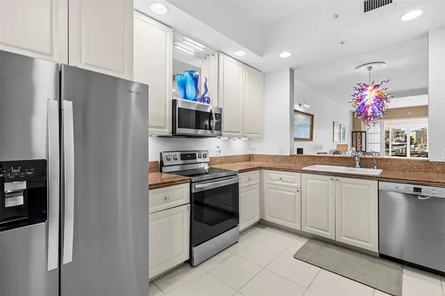 a kitchen with granite countertop stainless steel appliances a sink and cabinets