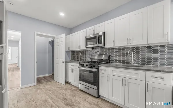 a kitchen with stainless steel appliances granite countertop a stove a sink and a refrigerator