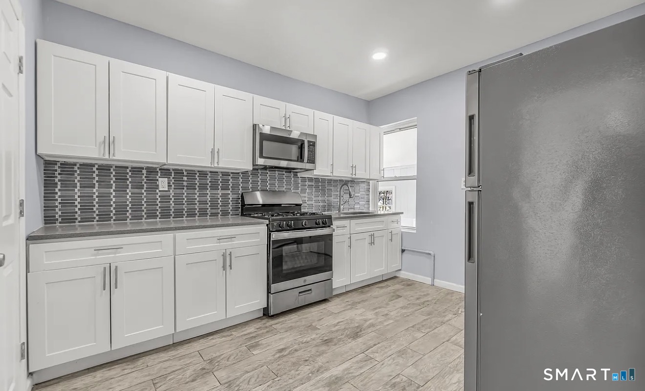 1220 Pembroke Street, Unit 3R Bridgeport, CT 06608 - Photo 2 of 12 a kitchen with white cabinets and appliances