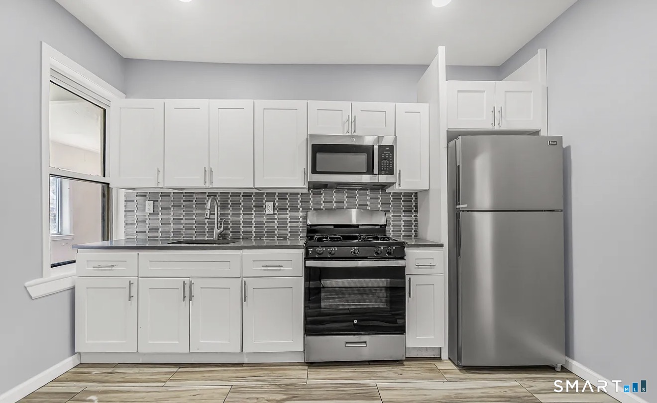 1220 Pembroke Street, Unit 3R Bridgeport, CT 06608 - Photo 3 of 12 a kitchen with refrigerator a microwave and cabinets