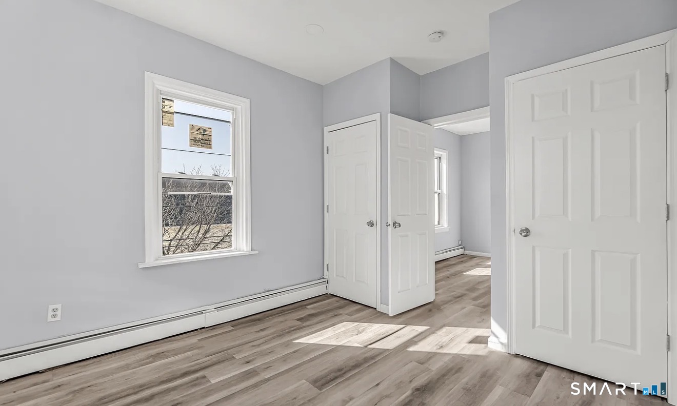 1220 Pembroke Street, Unit 3R Bridgeport, CT 06608 - Photo 5 of 12 a view of an empty room with wooden floor and a window