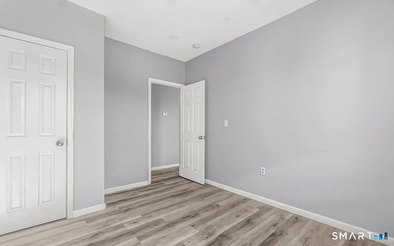 1220 Pembroke Street, Unit 3R Bridgeport, CT 06608 - Photo 8 of 12 a view of an empty room with wooden floor