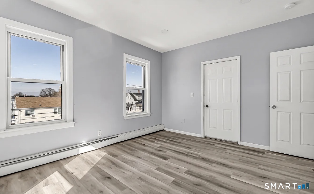 1220 Pembroke Street, Unit 3R Bridgeport, CT 06608 - Photo 9 of 12 a view of an empty room with window and wooden floor