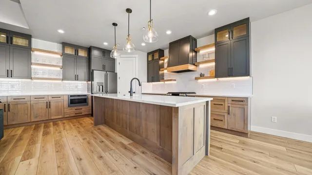 a large kitchen with stainless steel appliances a lot of counter space and a wooden floors