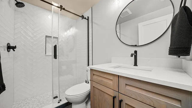 a bathroom with a sink a toilet and a mirror