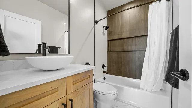 a bathroom with a granite countertop sink toilet and shower