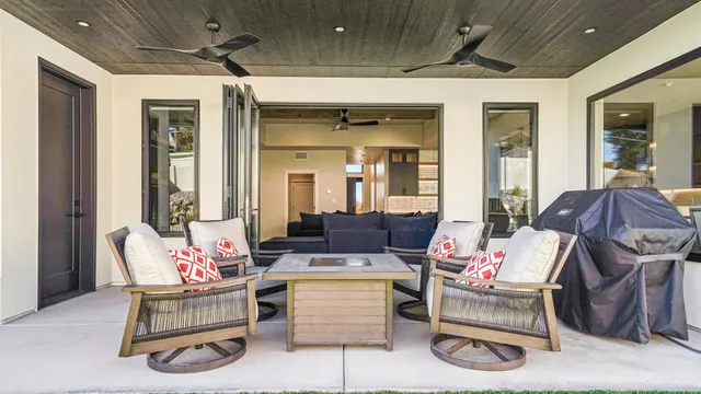 a living room with furniture a flat screen tv and a chandelier